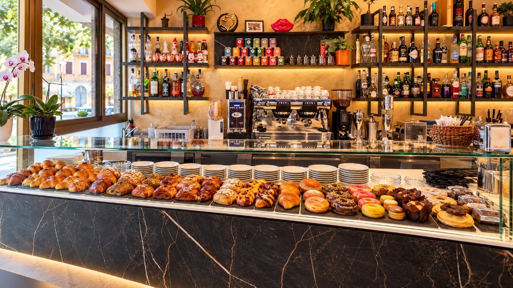 Bancone del Glamour Bar con vetrina pasticceria, macchina del caffè e scaffali